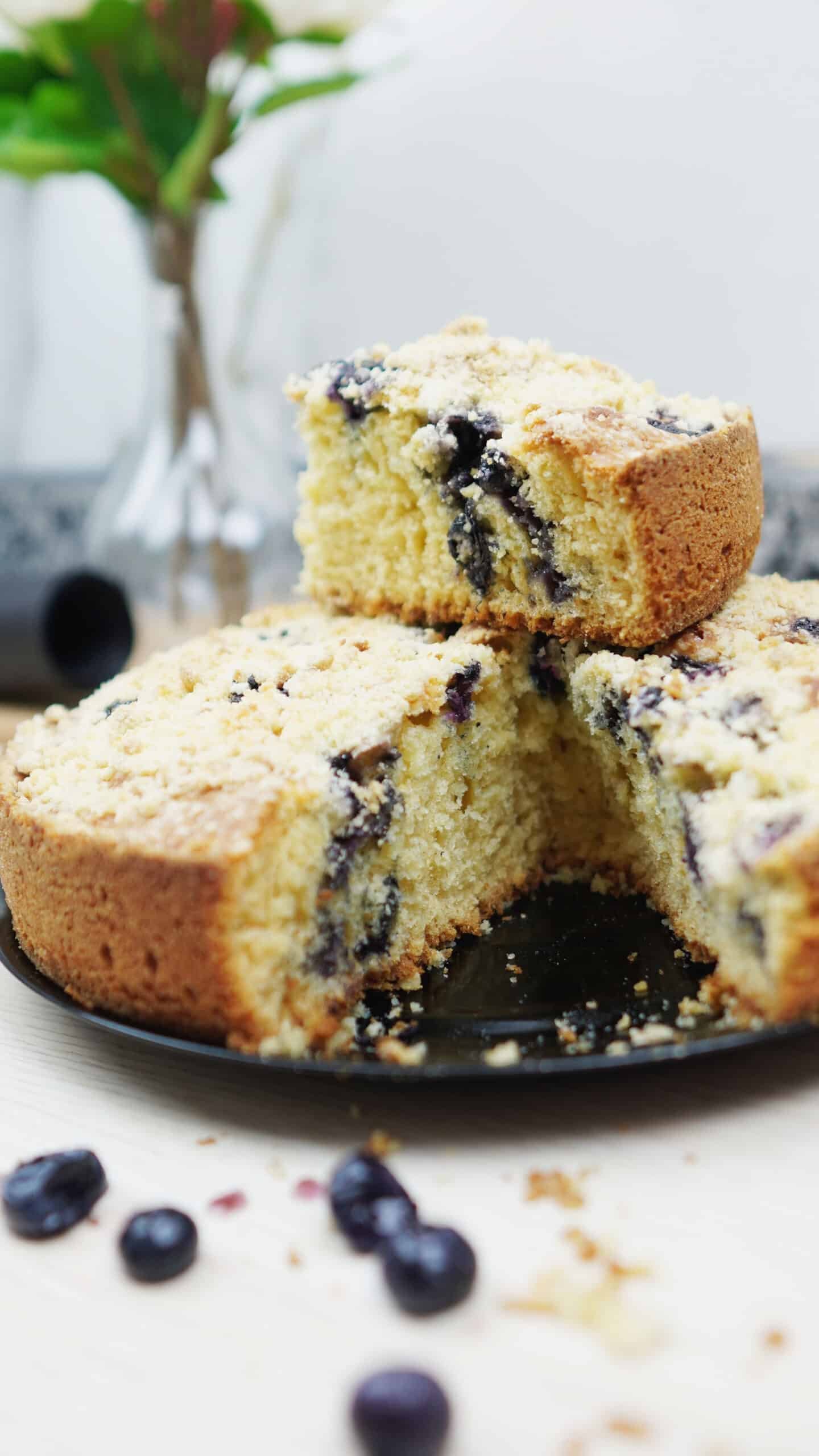 Sliced blueberry crumb cake showing soft crumb and blueberries inside