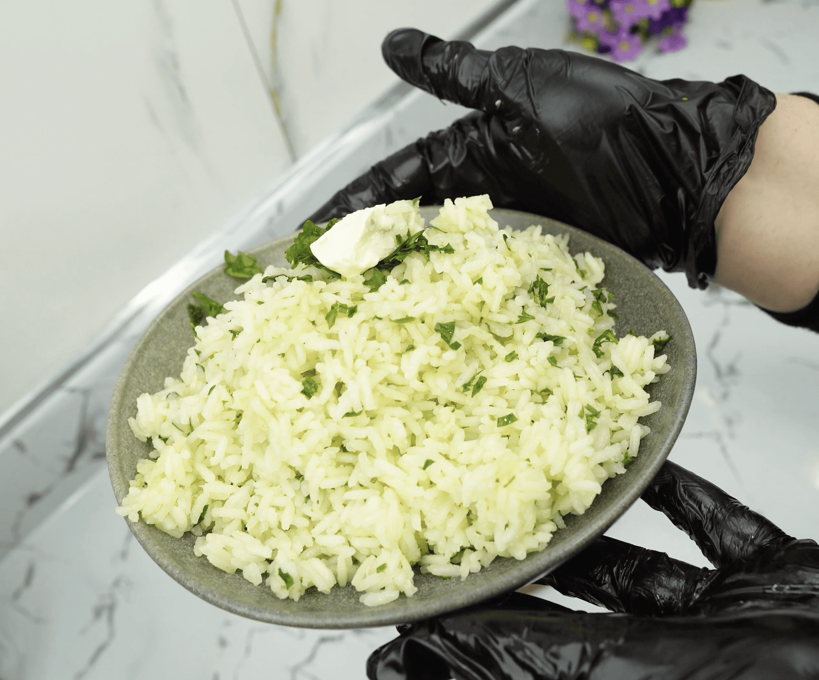 Garlic butter rice served in a bowl with parsley and a pat of butter on top