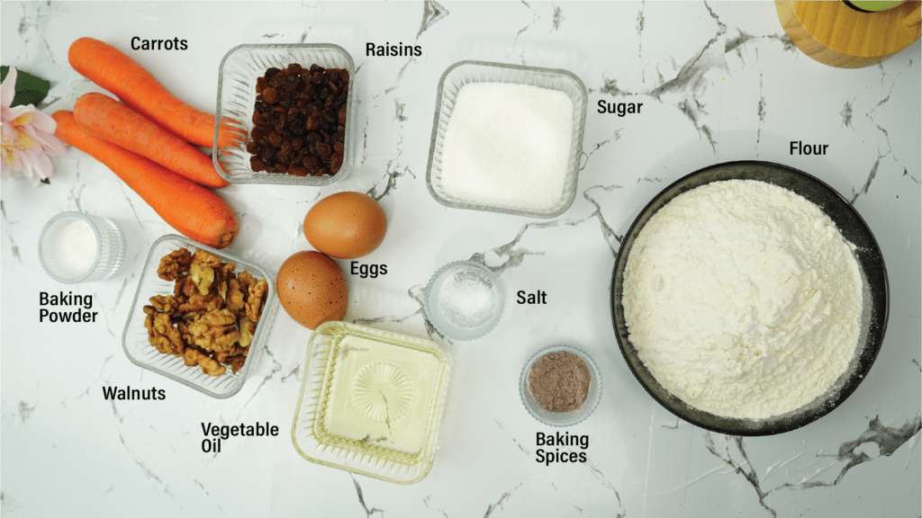 overhead view of carrots flour sugar eggs walnuts raisins oil and spices