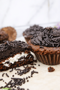 Cream-filled chocolate cupcake cut open showing the creamy center