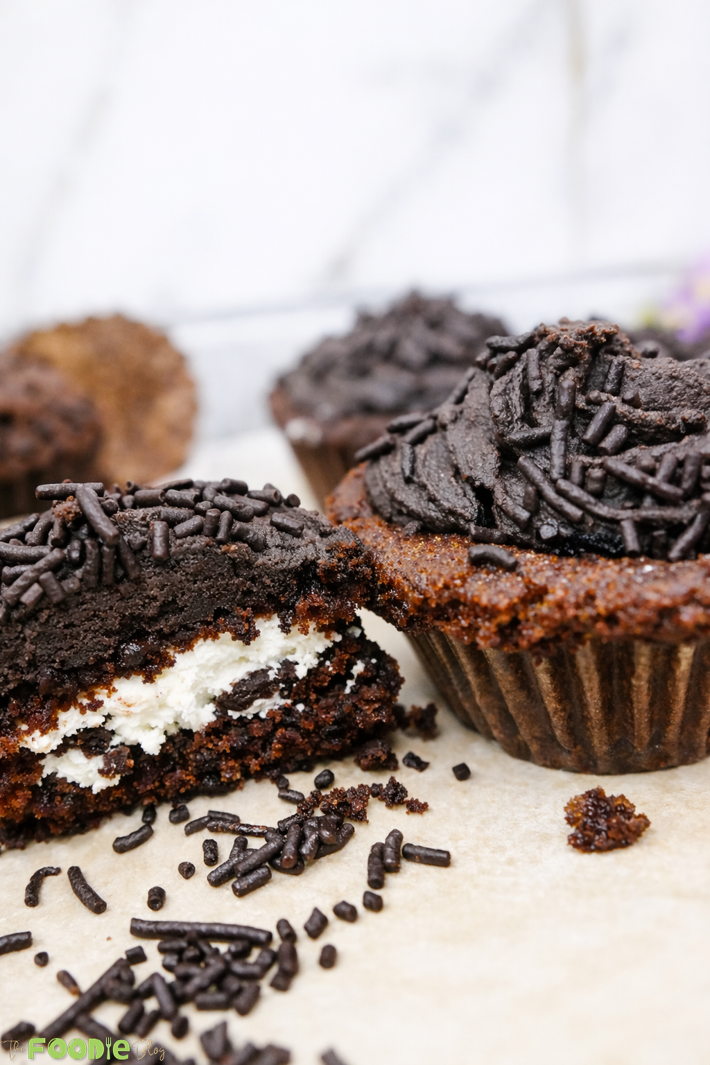 Cream-filled chocolate cupcake cut open showing the creamy center