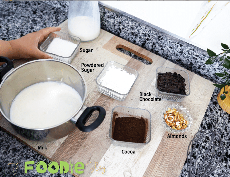 Milk, sugar, cornstarch, cocoa powder, dark chocolate, and walnuts arranged on a cutting board.