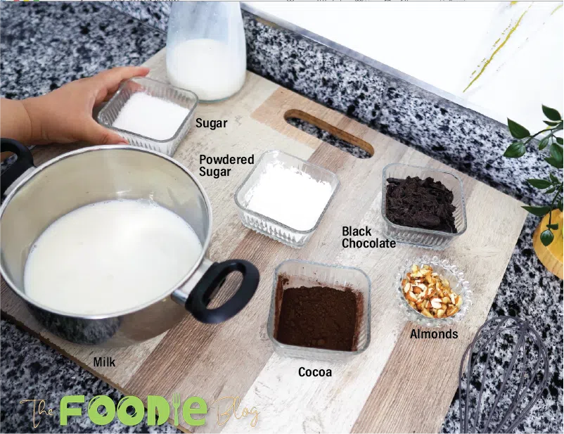 Milk, sugar, cornstarch, cocoa powder, dark chocolate, and walnuts arranged on a cutting board.
