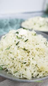 Fluffy white rice grains with chopped herbs in a bowl