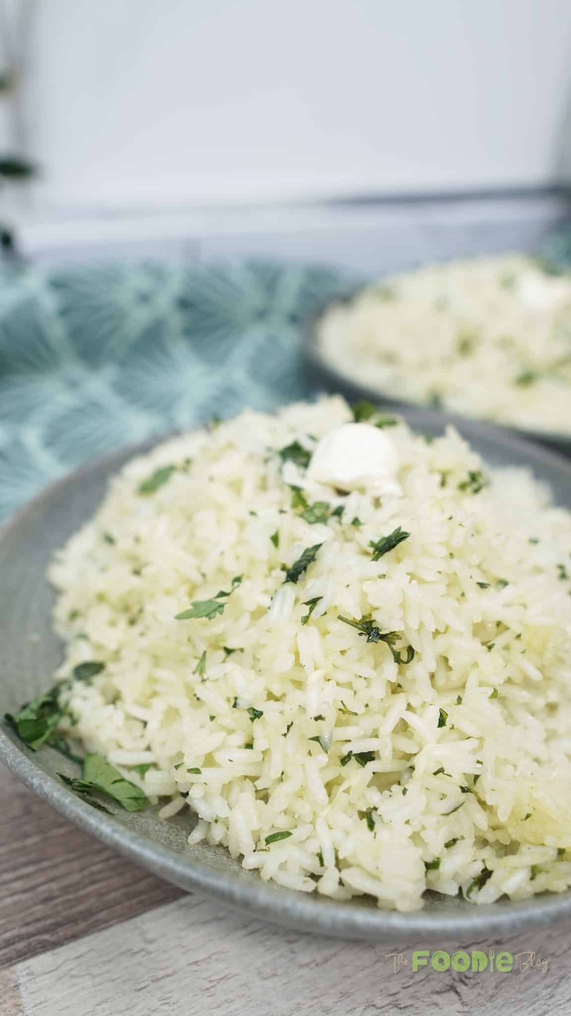 Bowl of garlic butter rice in the foreground with a second bowl blurred in the background