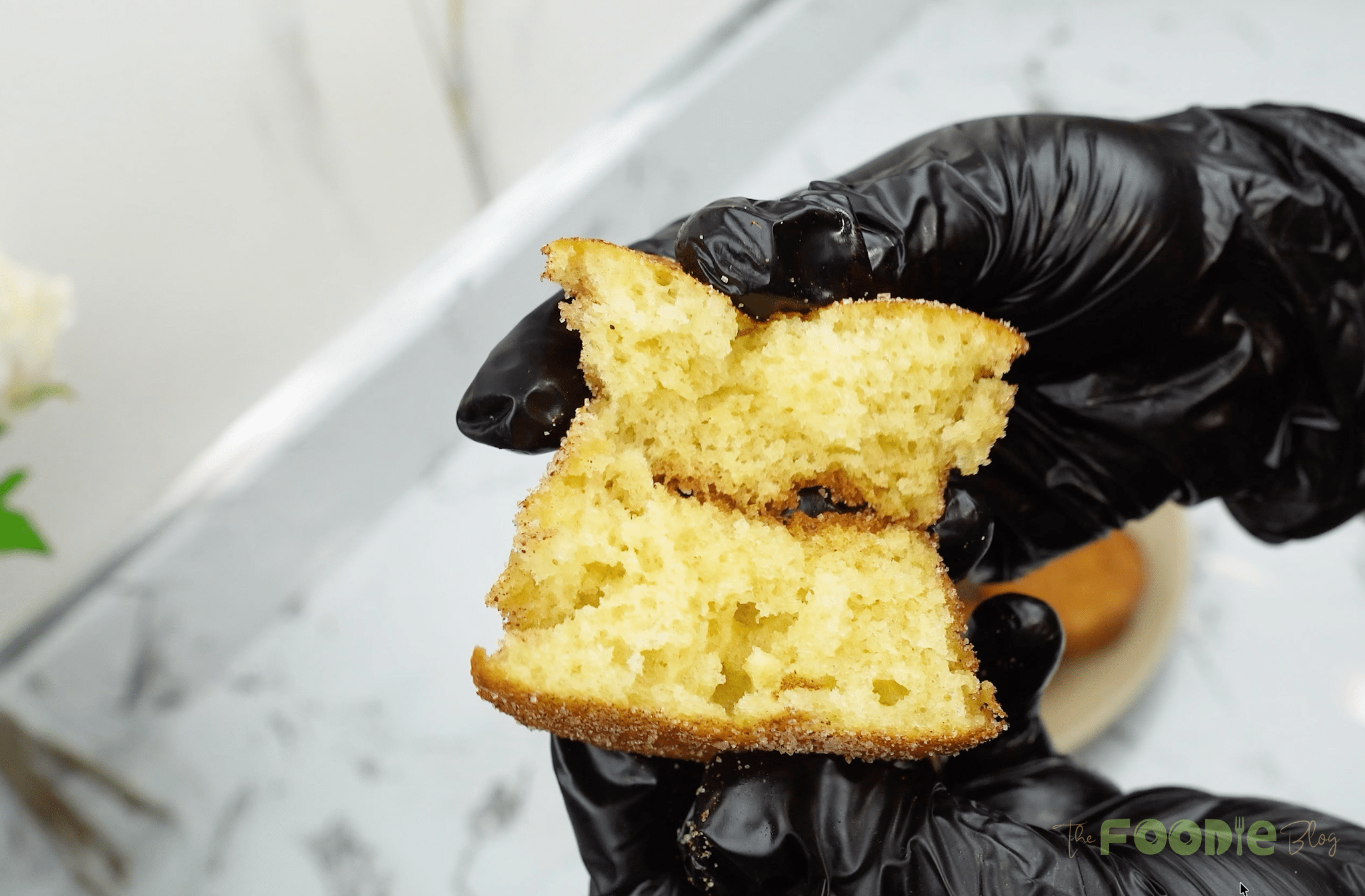 Close-up of a mini cinnamon muffin broken in half showing the soft crumb