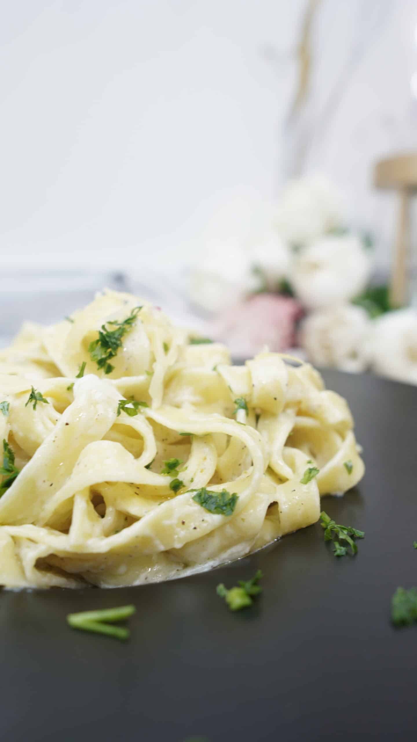 Close-up of creamy garlic parmesan pasta on a black plate