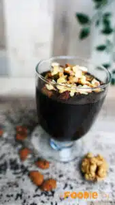 Warm chocolate pudding being poured into small glass cups.