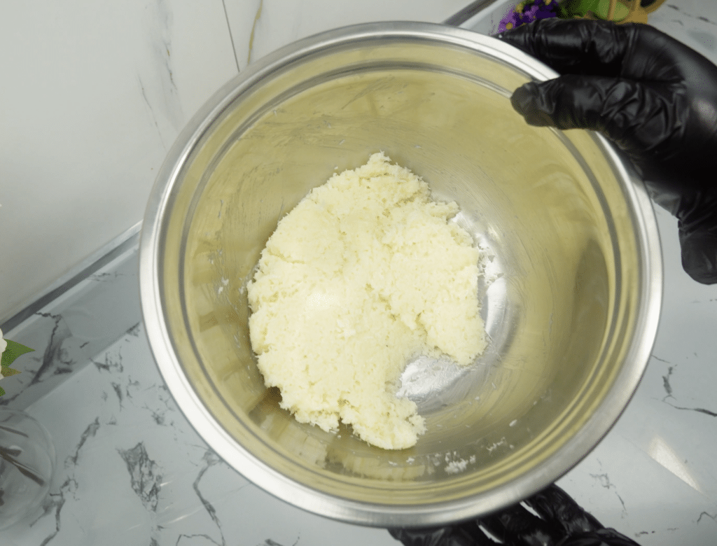 Thick coconut and condensed milk mixture pressed together in a metal bowl