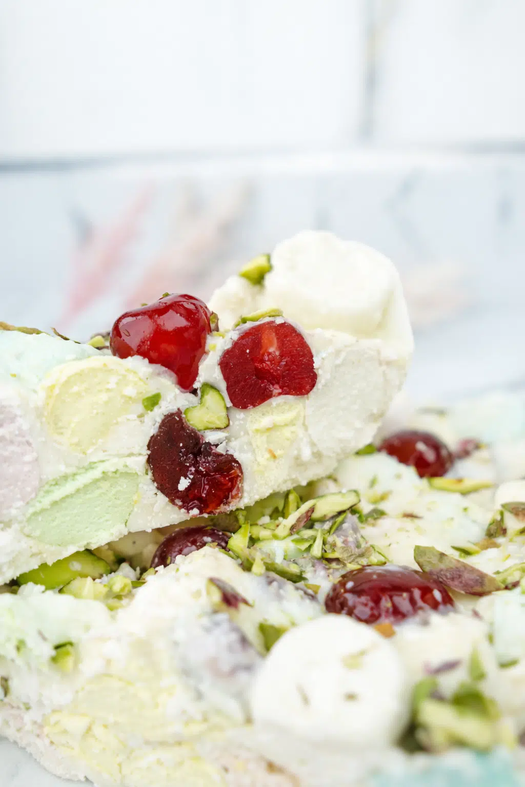 Pastel white chocolate rocky road with marshmallows, glacé cherries, and pistachios cut into pieces
