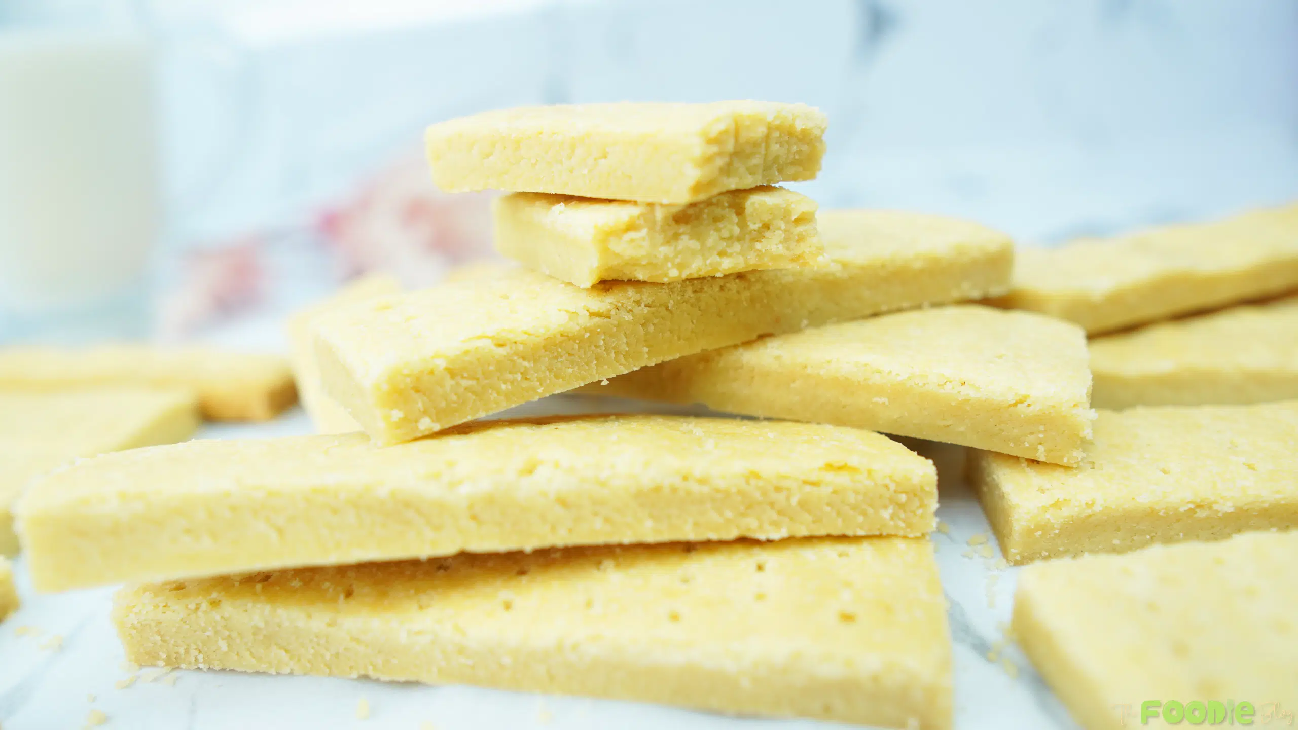 Close-up of thick shortbread cookie bars stacked with a few pieces in the background
