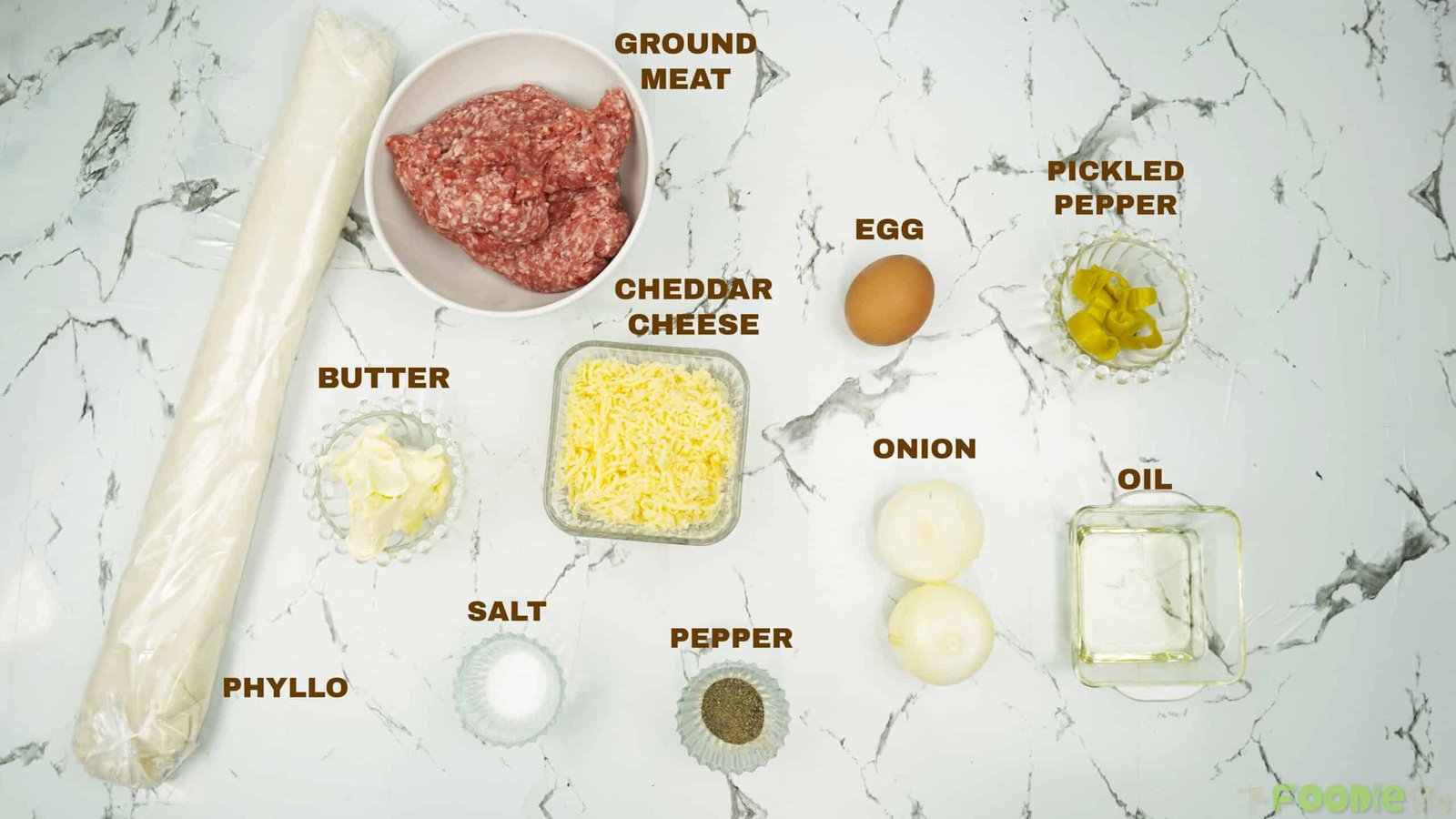 Ingredients for crispy minced meat cigars including phyllo dough, ground meat, cheddar cheese, onion, egg, butter, oil, and pickled pepper
