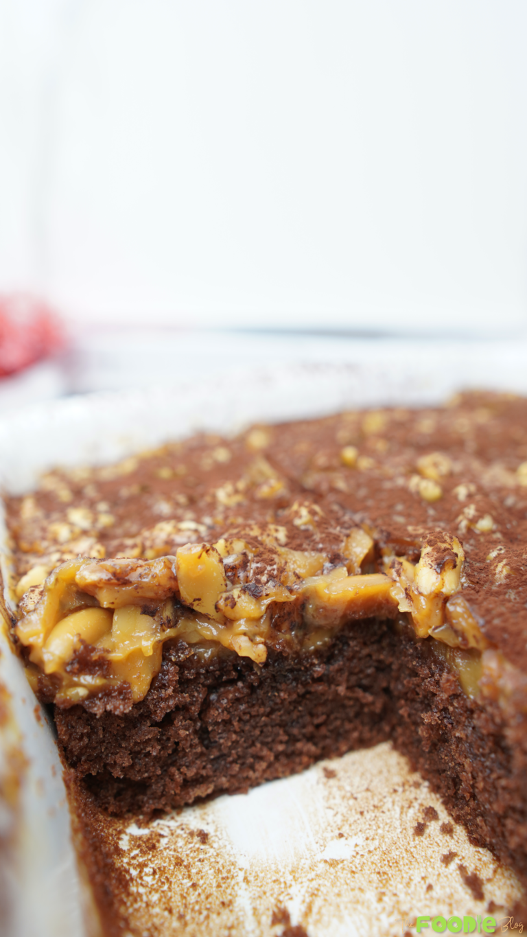Close view of caramel peanut topping over chocolate cake inside the baking dish