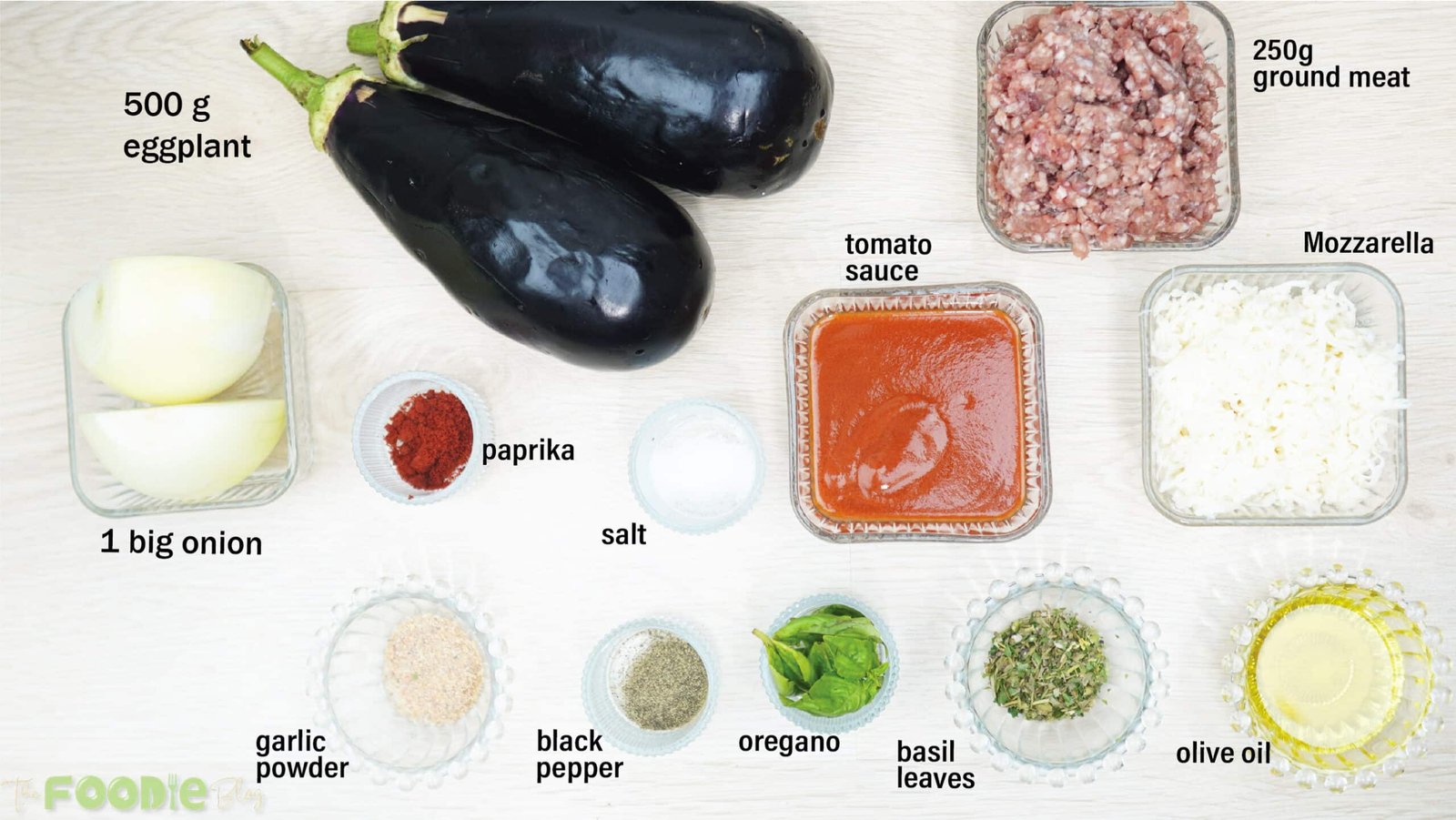 Ingredients for Cheesy Beef-Stuffed Eggplant Boats arranged on a white surface