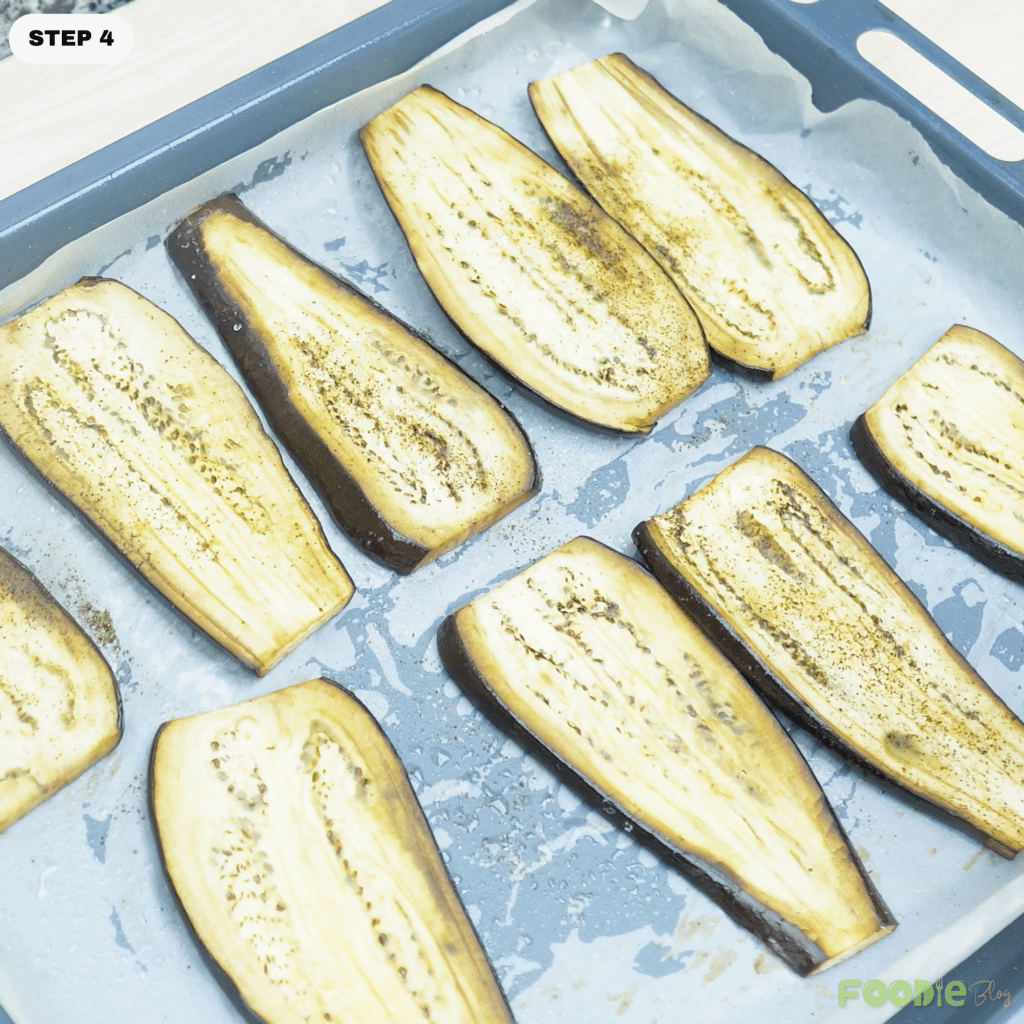 Roasted eggplant slices on a lined sheet pan for Cheesy Beef-Stuffed Eggplant Boats