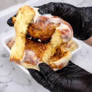 Soft cinnamon roll pulled apart showing the fluffy interior and cinnamon sugar filling.