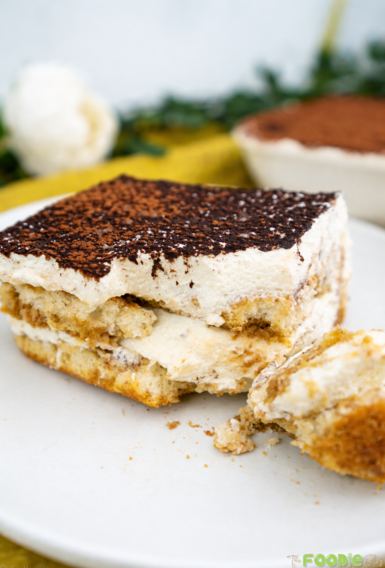 Classic tiramisu slice on a plate with cocoa powder topping