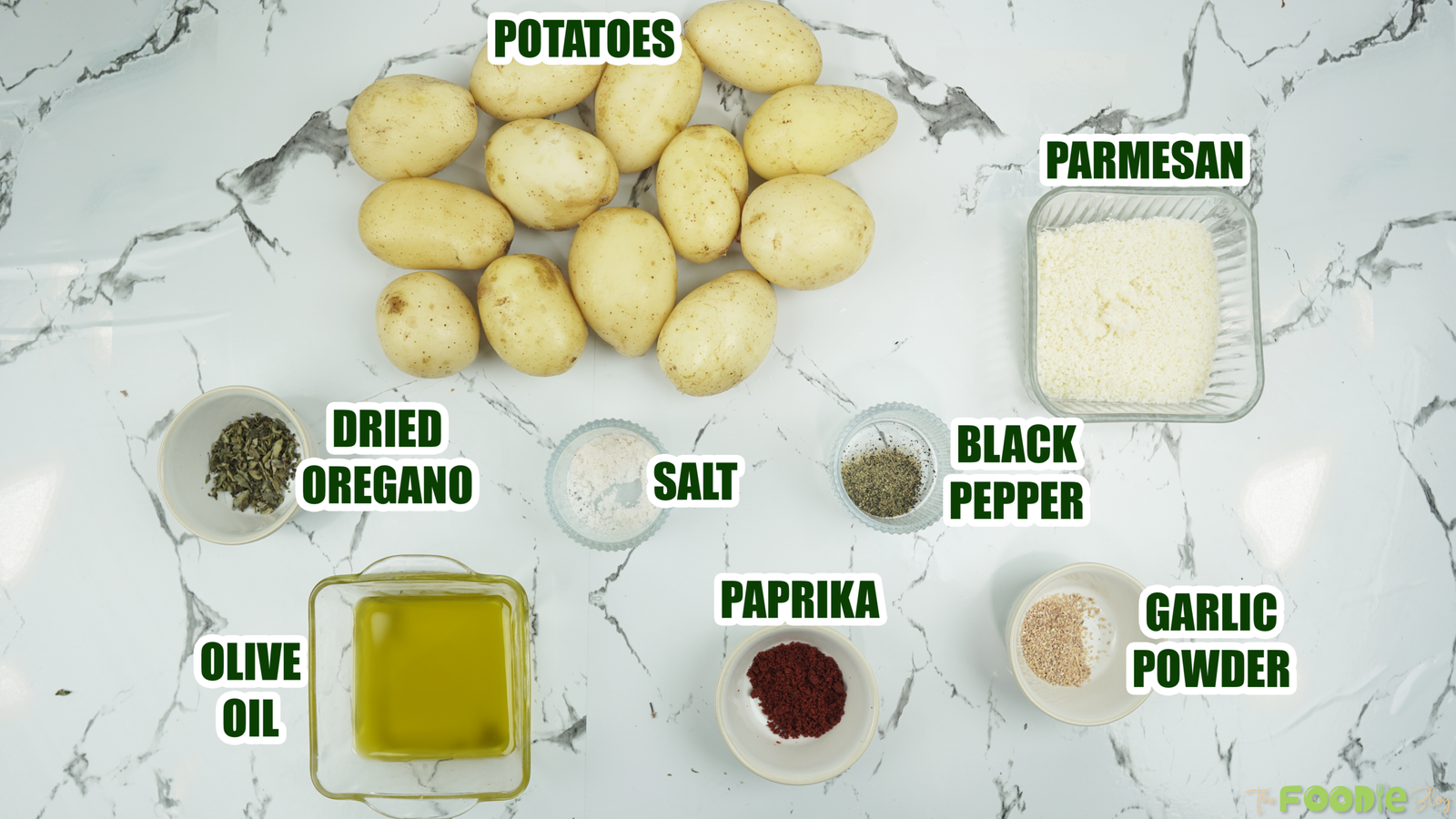 Baby potatoes, Parmesan, olive oil, and seasonings laid out on a countertop