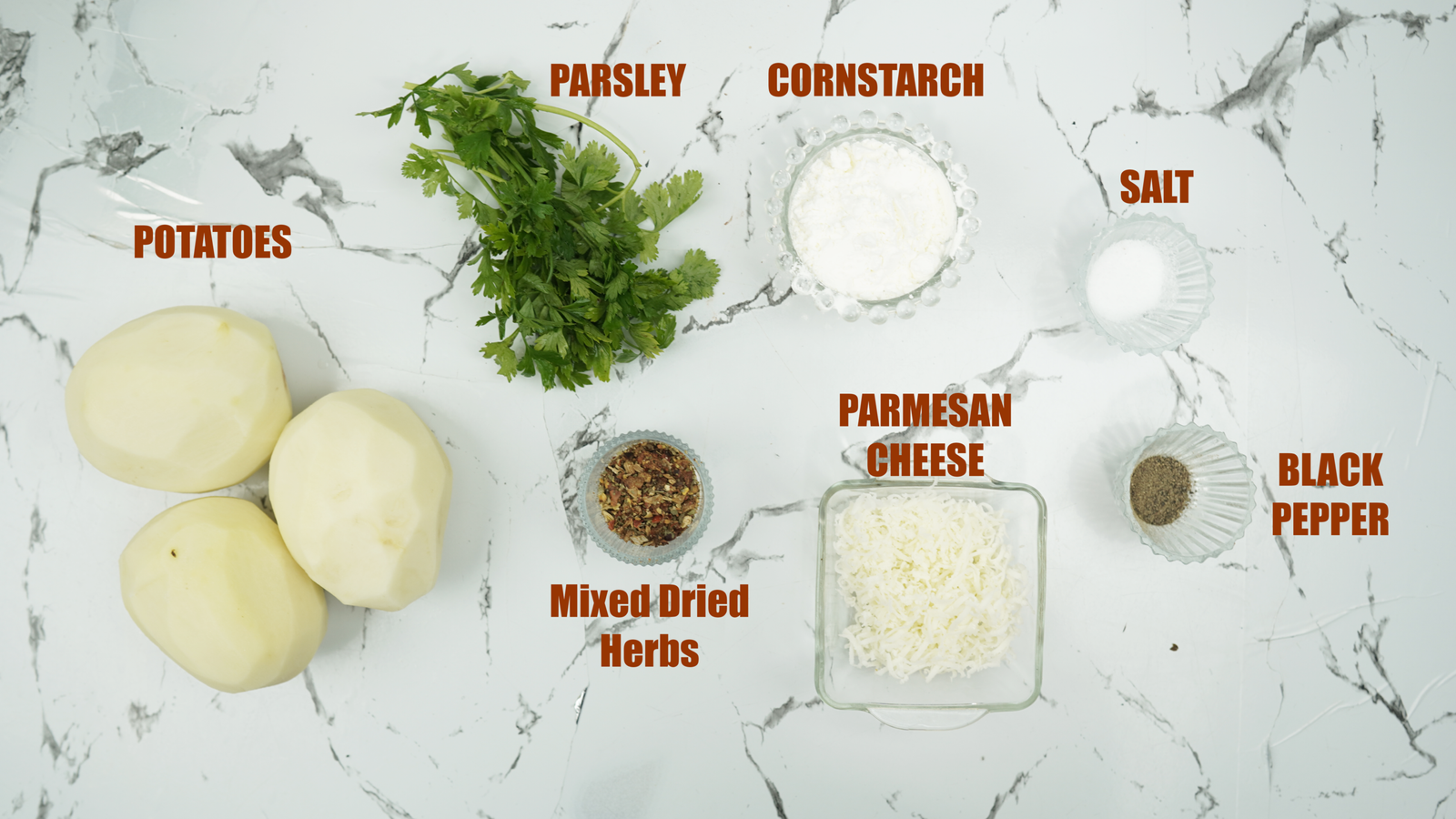 Potatoes, parsley, cornstarch, Parmesan, salt, pepper, and dried herbs on a counter