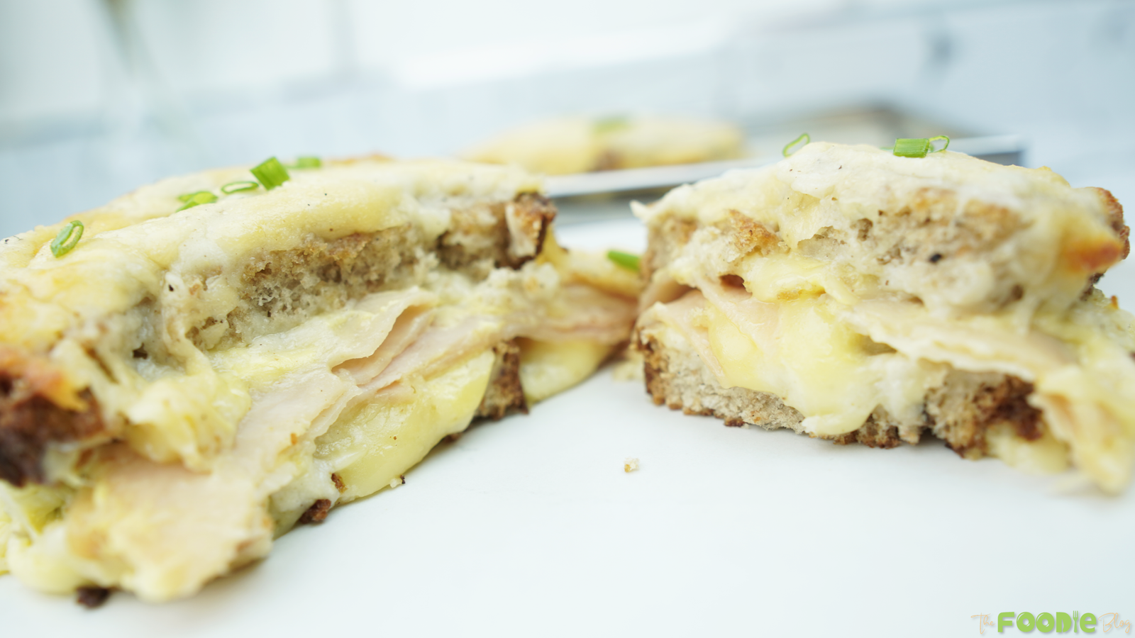 Close-up of the sandwich cut open showing ham, melted cheese, and béchamel under toasted bread