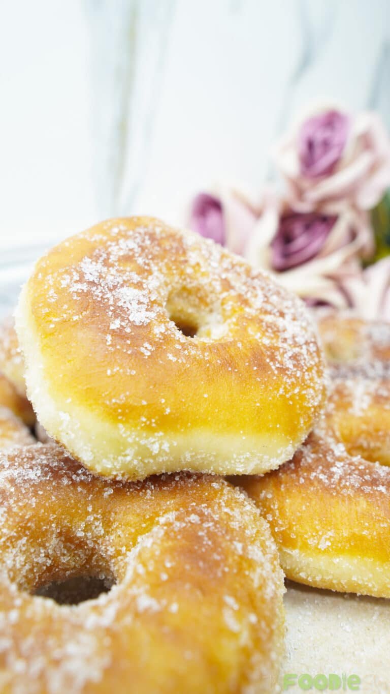 Close-up of a fluffy fried donut coated with granulated sugar