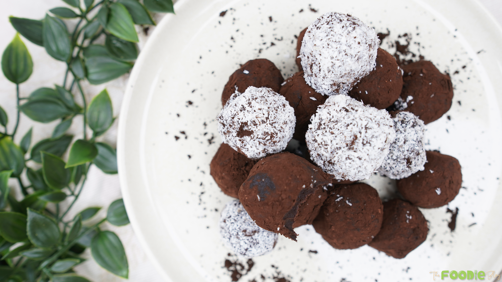 Finished chocolate truffles arranged on a white plate with cocoa crumbs