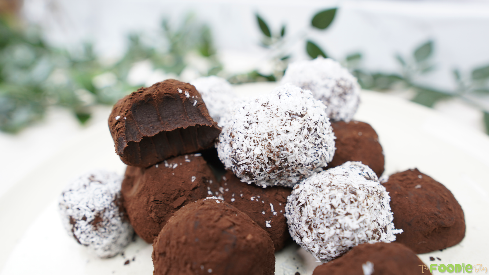 Cocoa-dusted and coconut-coated chocolate truffles stacked on a plate