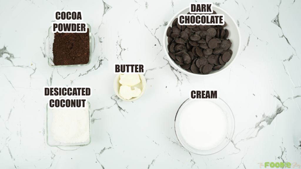 Dark chocolate, cream, butter, cocoa powder, and desiccated coconut on a counter