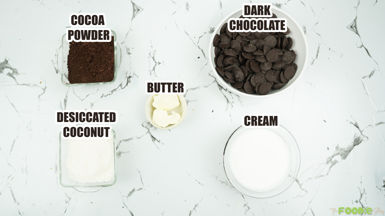 Dark chocolate, cream, butter, cocoa powder, and desiccated coconut on a counter