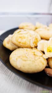 Close-up of Greek Cretan biscuits topped with almond flakes on a black plate