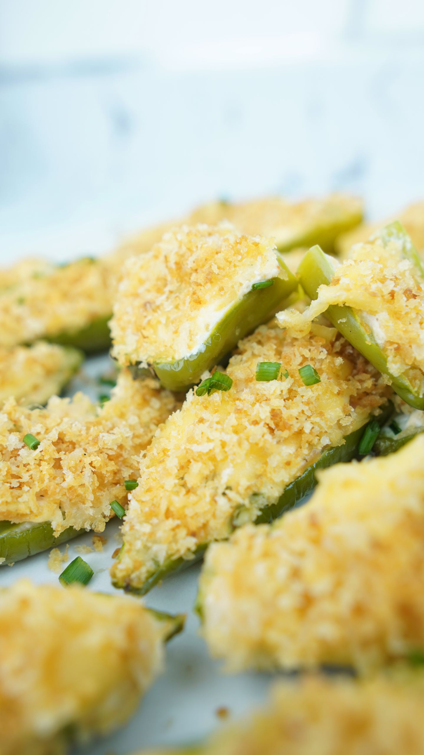 Close-up of baked jalapeño poppers with melted cheese and crunchy panko topping