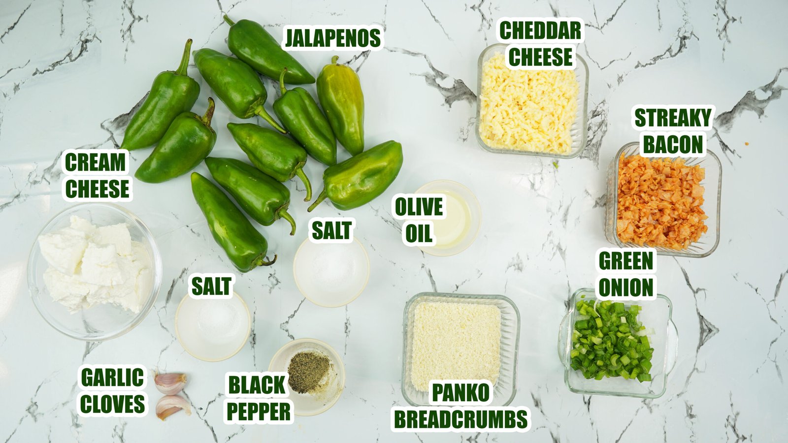 Jalapeños, cream cheese, cheddar, bacon, green onion, garlic, and panko arranged on a counter
