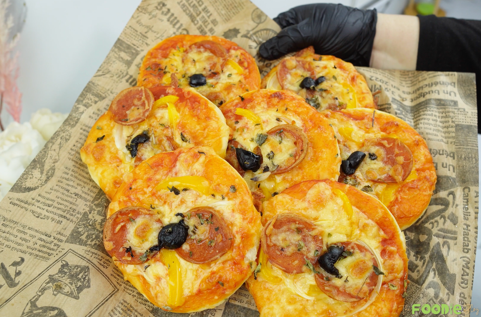 Freshly baked mini pepperoni pizzas with melted cheese and olives