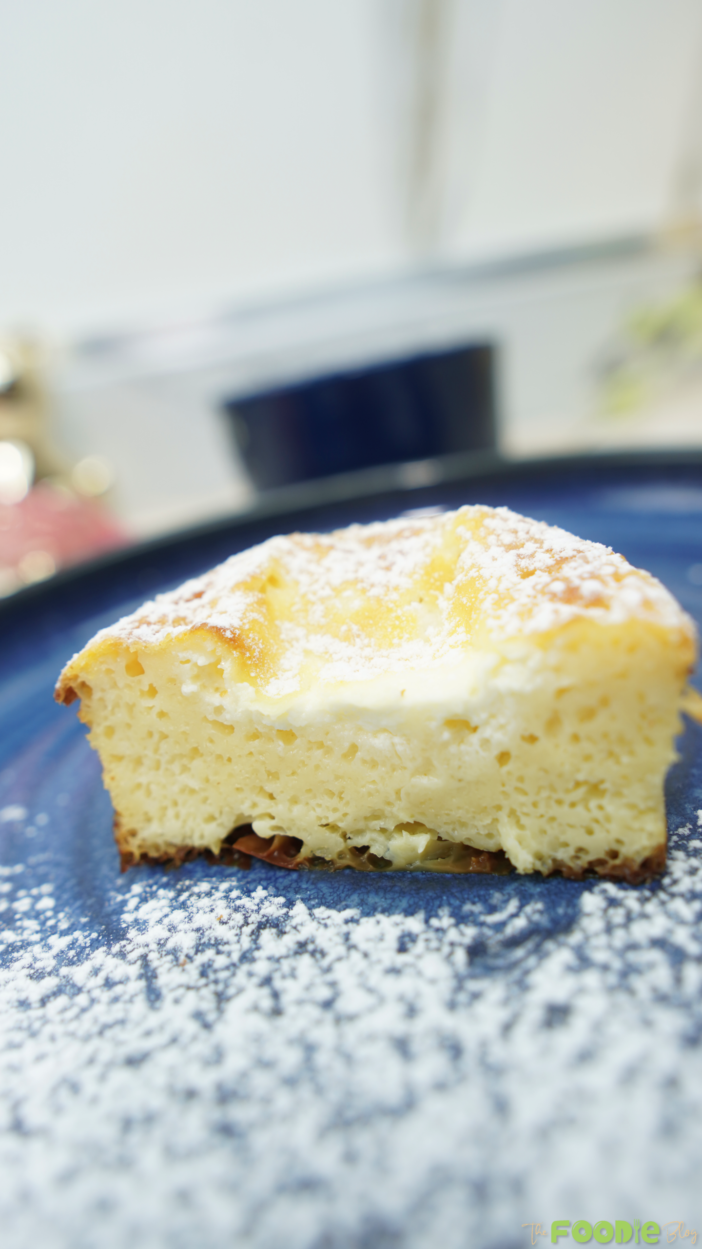 Close-up of a slice showing the airy, creamy interior on a blue plate