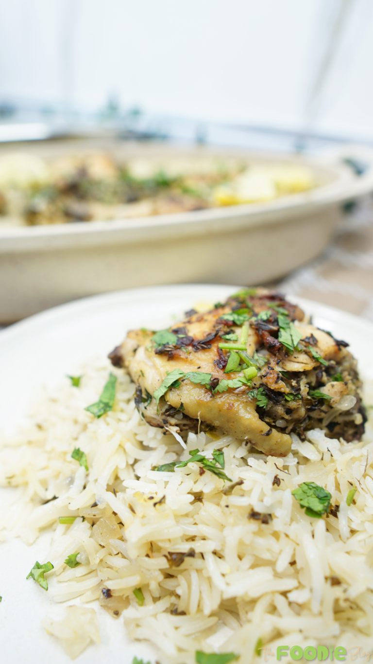 Close-up of a piece of chicken on lemon herb rice with parsley on top