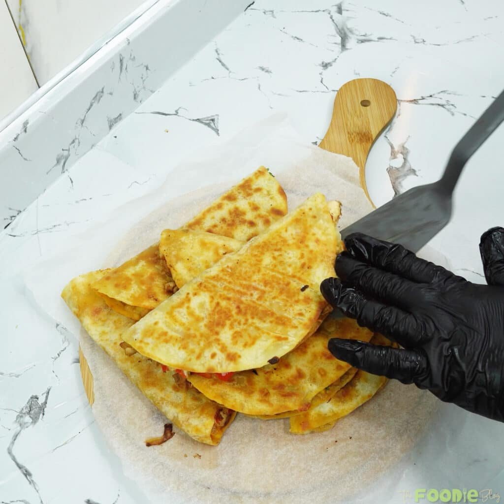 Stack of golden toasted quesadillas on parchment ready to serve