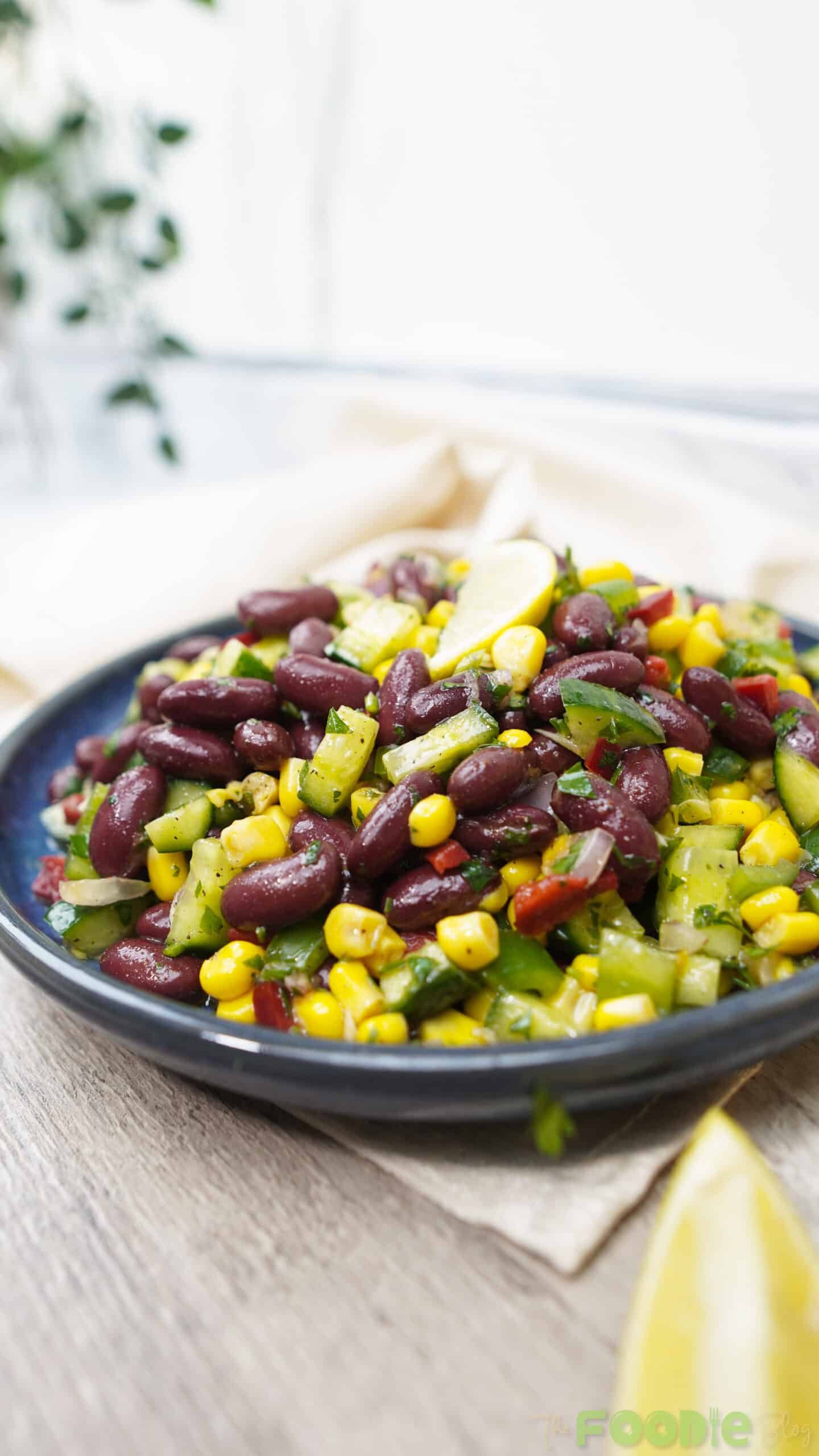 Close-up of red bean salad showing glossy beans, diced cucumbers, and corn kernels