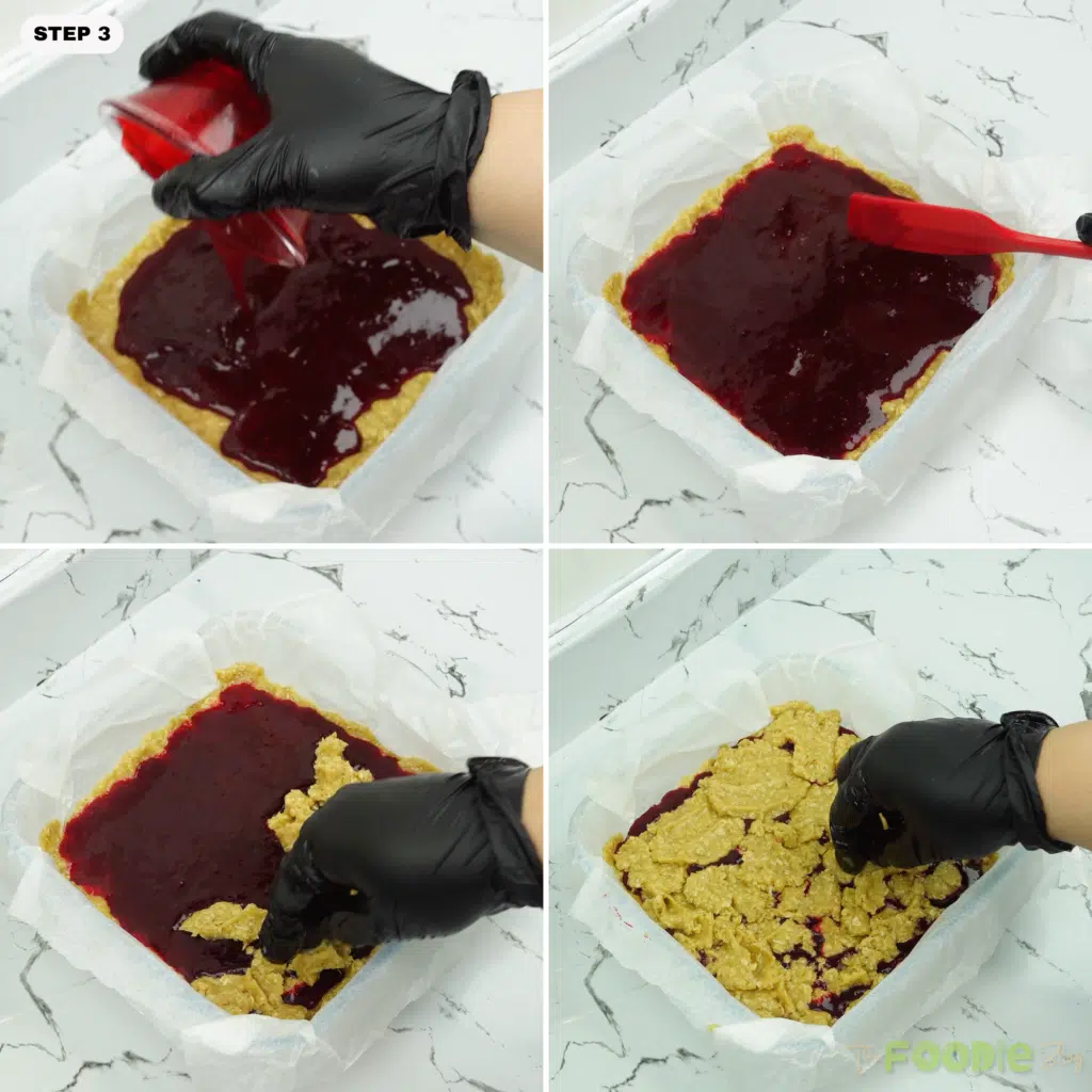 Raspberry jam spread over the base and the remaining dough crumbled on top