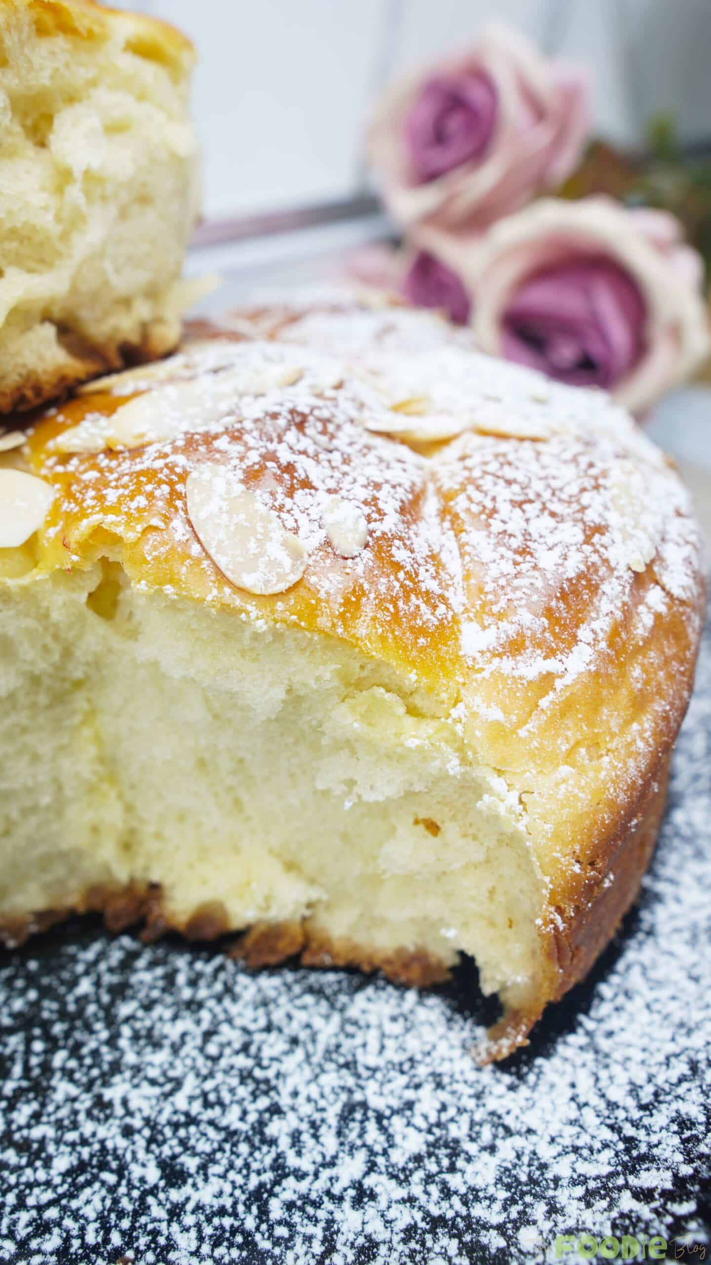 Close-up of a brioche slice showing a light, fluffy crumb with almond topping