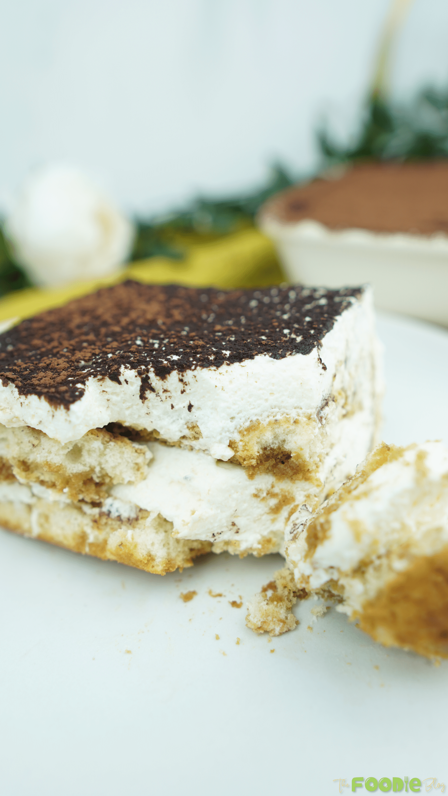 Tiramisu slice on a plate with a bite taken, showing the soft interior.