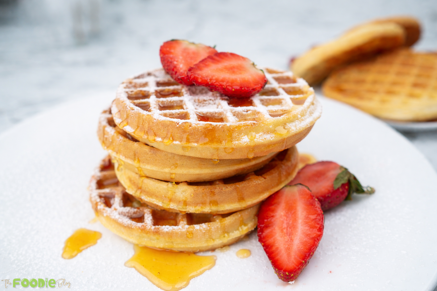 Side-by-side collage of plain waffles and waffles topped with syrup and strawberries