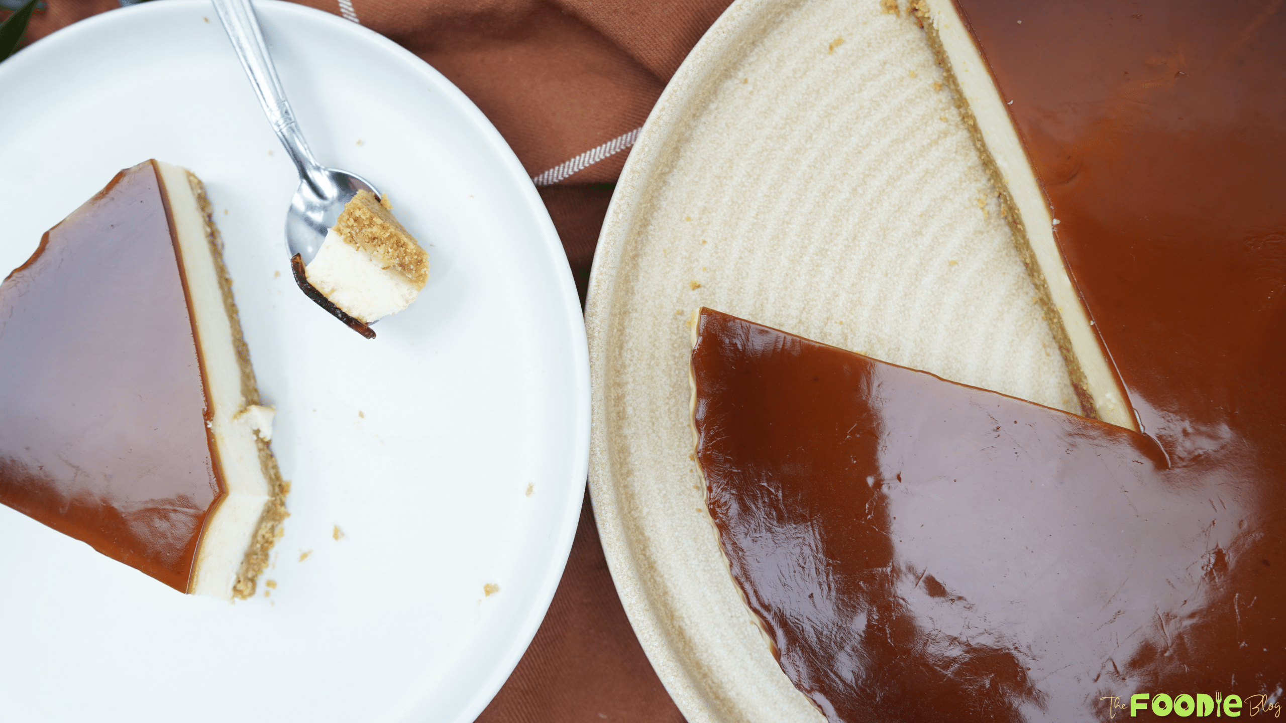 Overhead view of yogurt cheesecake with coffee caramel topping, with one slice served on a white plate and a bite on a fork.