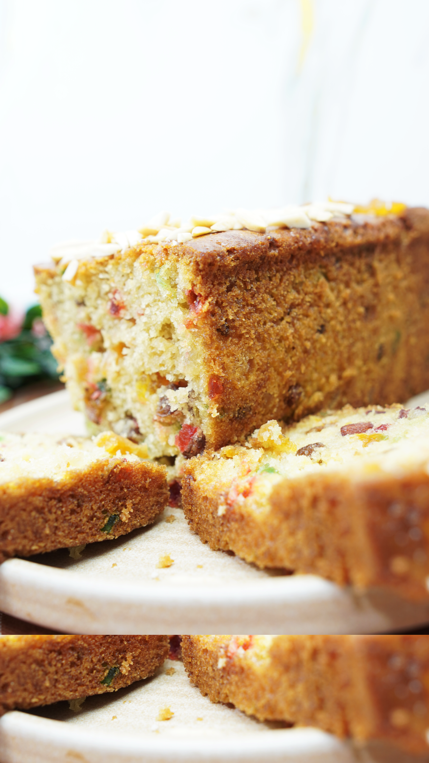 Sliced candied fruit cake loaf showing a moist crumb with raisins and mixed candied fruit pieces.