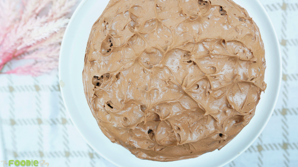 Overhead view of a frosted Chocolate Fudge Cake with swirled chocolate ganache topping.