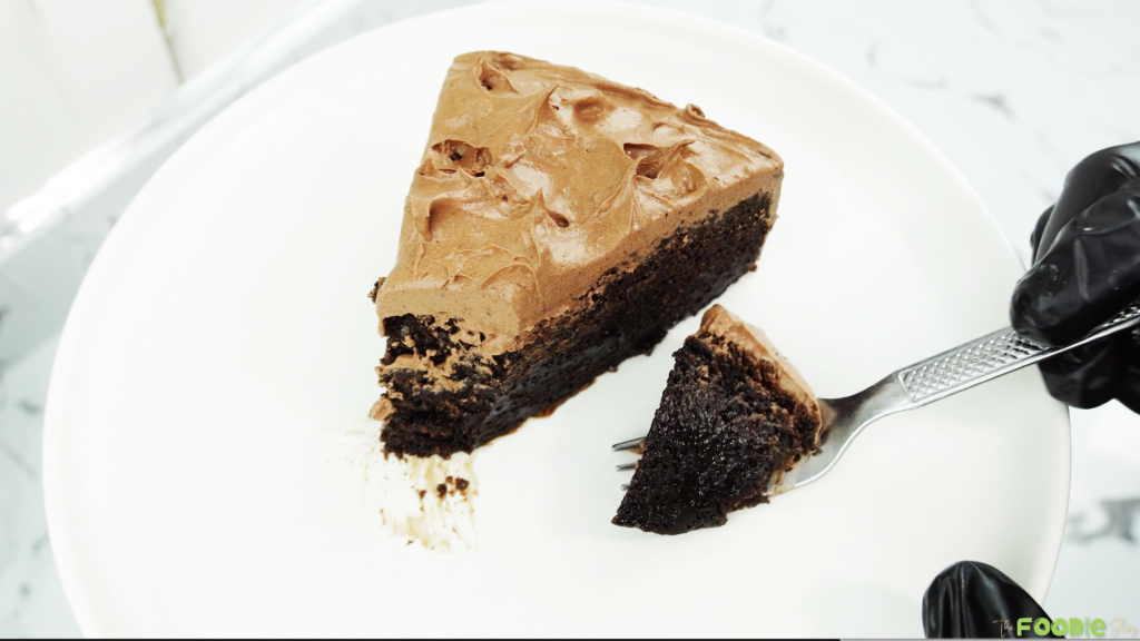 Chocolate Fudge Cake slice served on a white plate with chocolate ganache frosting.