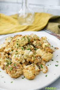 Plate of chou-fleur rôti roasted cauliflower florets with garlic, olive oil, black pepper, and parsley