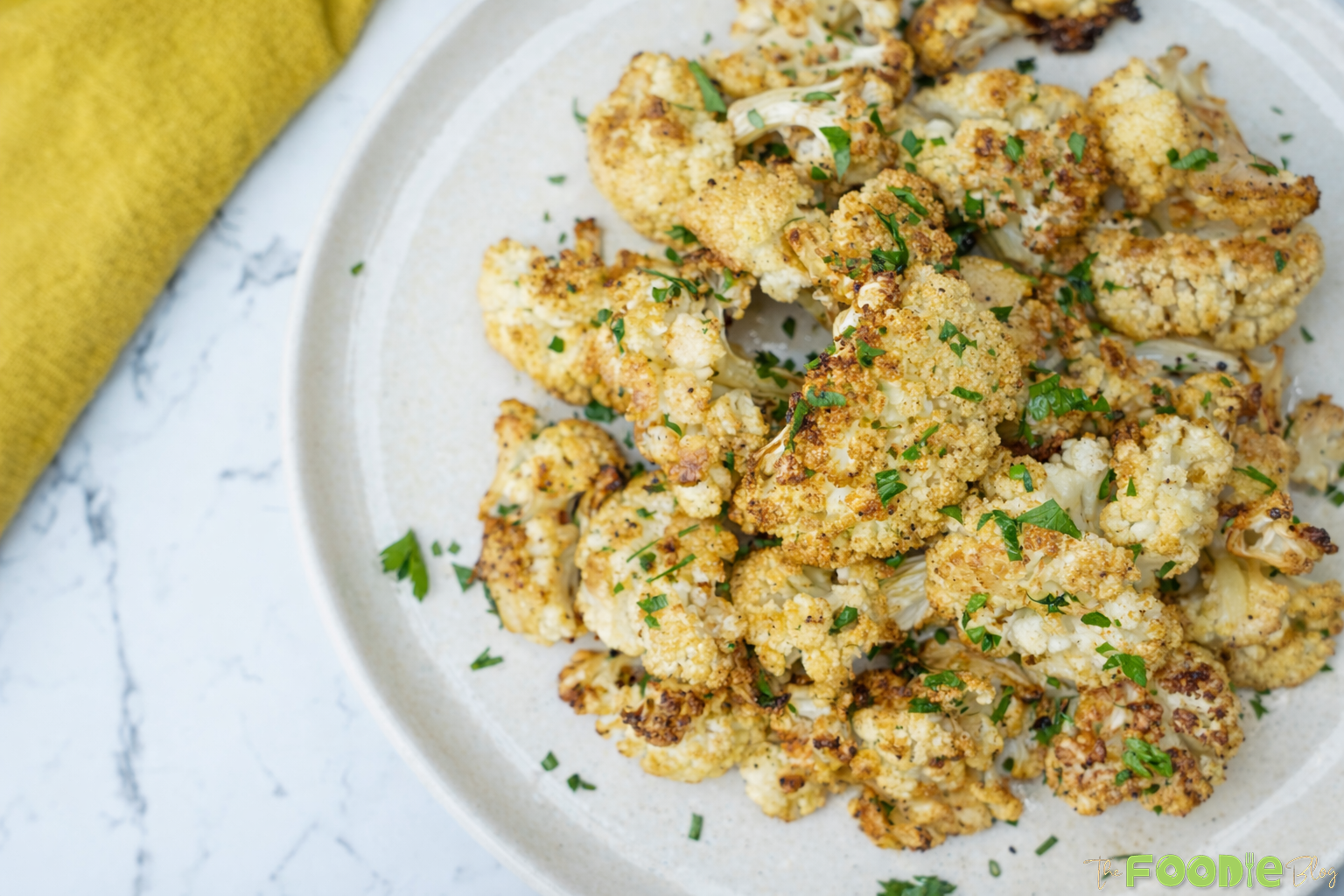 Plate of chou-fleur rôti roasted cauliflower florets with garlic, olive oil, black pepper, and parsley