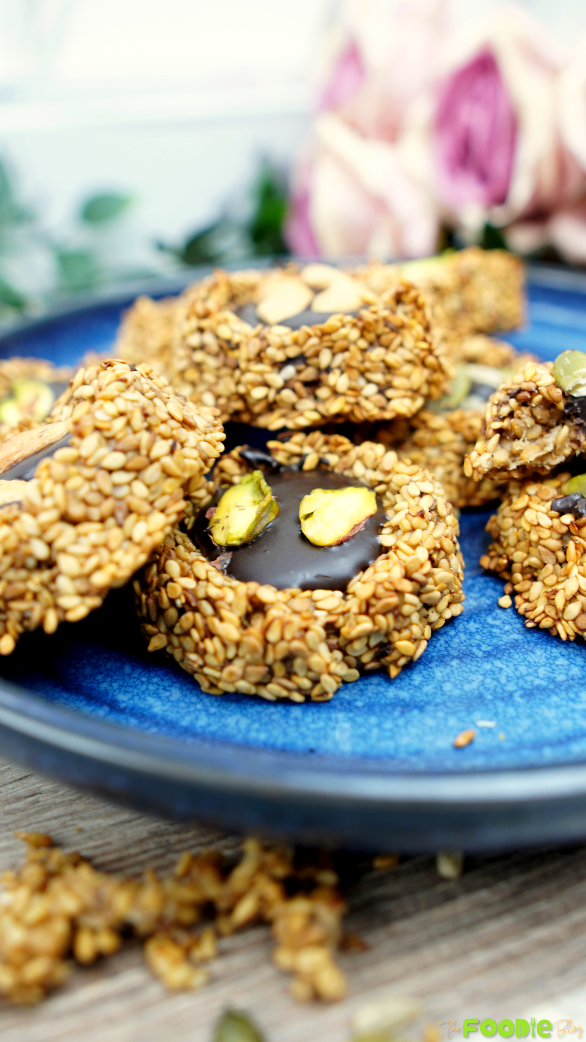 Banana sesame cookies topped with chocolate and seeds on a blue plate