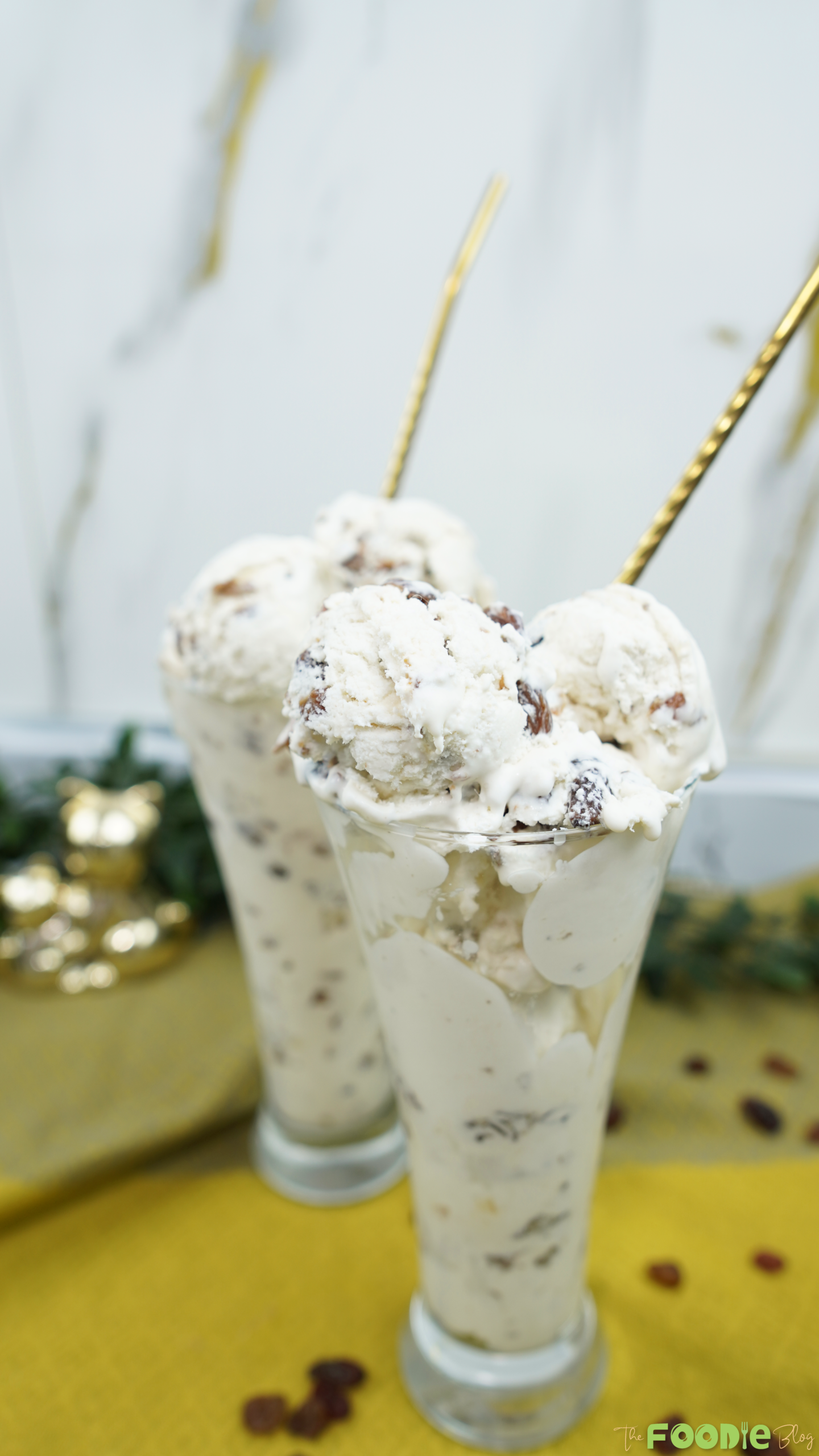 Scoops of rum raisin ice cream served in tall glasses with spoons