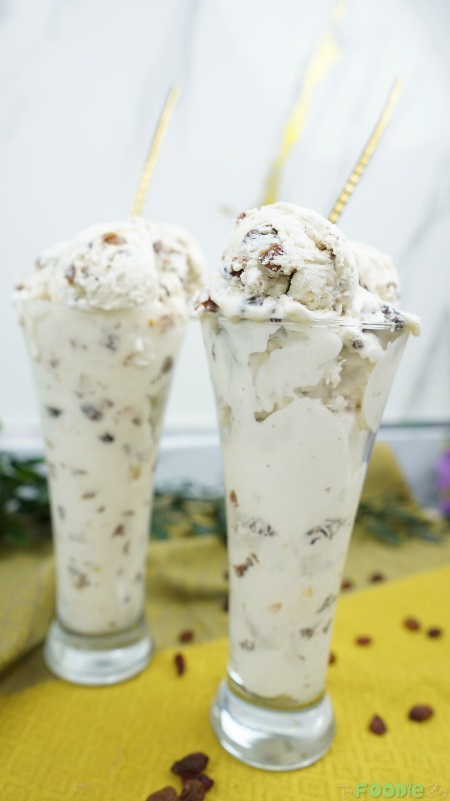 Two tall glasses filled with Easy Rum Ice Cream with rum-soaked raisins